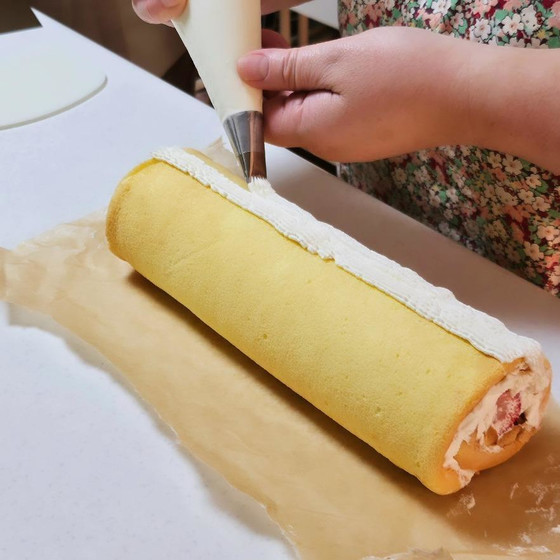 生クリームと苺を巻いてトップにも絞りを入れます♪